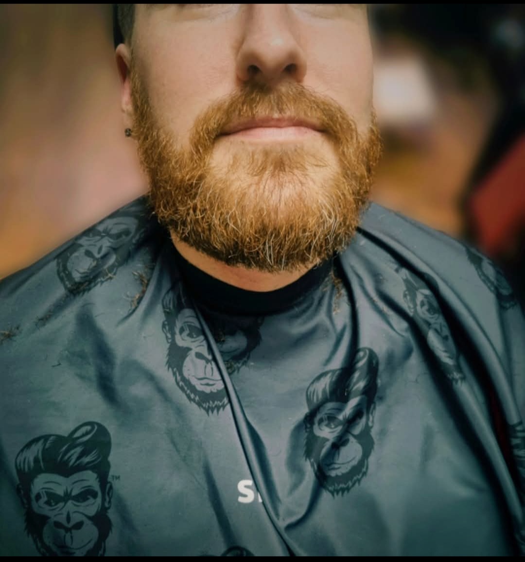 Customer with a full beard in a Slick Gorilla cape at Swan Street Barber Shop